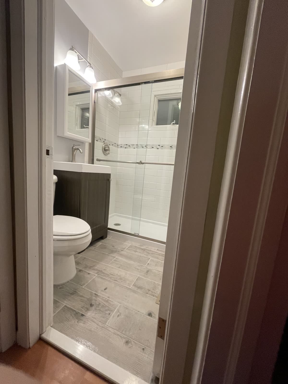 Completed bathroom renovation with tiled shower and vanity